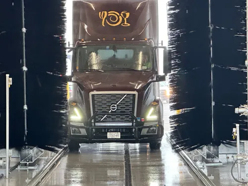 Truck moving through an InterClean fleet wash system with side brushes